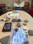 Classroom table with rocks, volcanoes and fossils set up for a workshop
