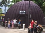 Outdoor planetarium with people waiting to go inside