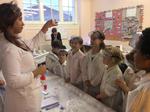 A group of children with lab coats and goggles in a science experiments class in a school in the UK