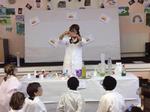 A science teacher explaining experiments to a group of children in a science class in a school in the UK